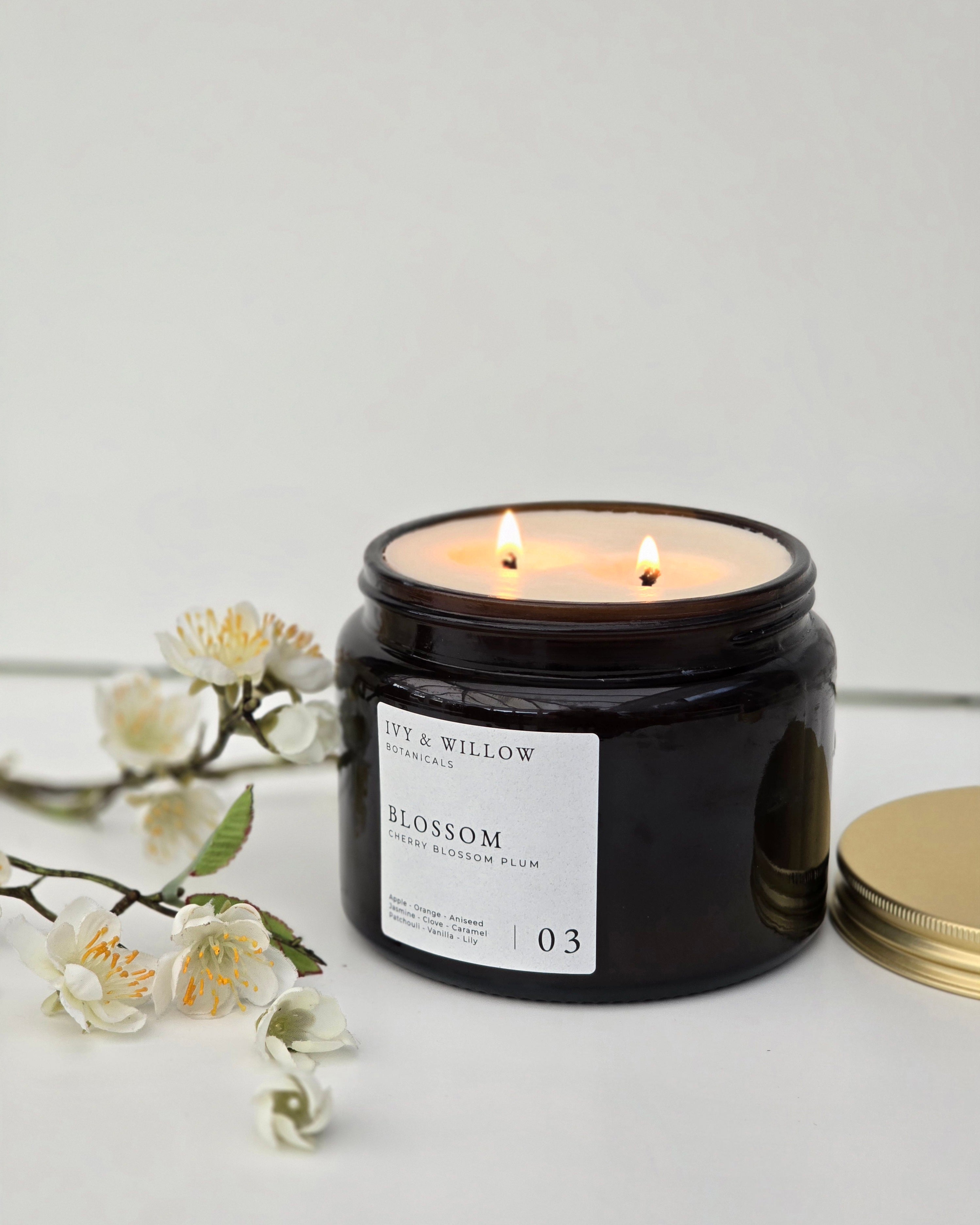 Black candle jar with 'Fay & Willow' label on a light gray background