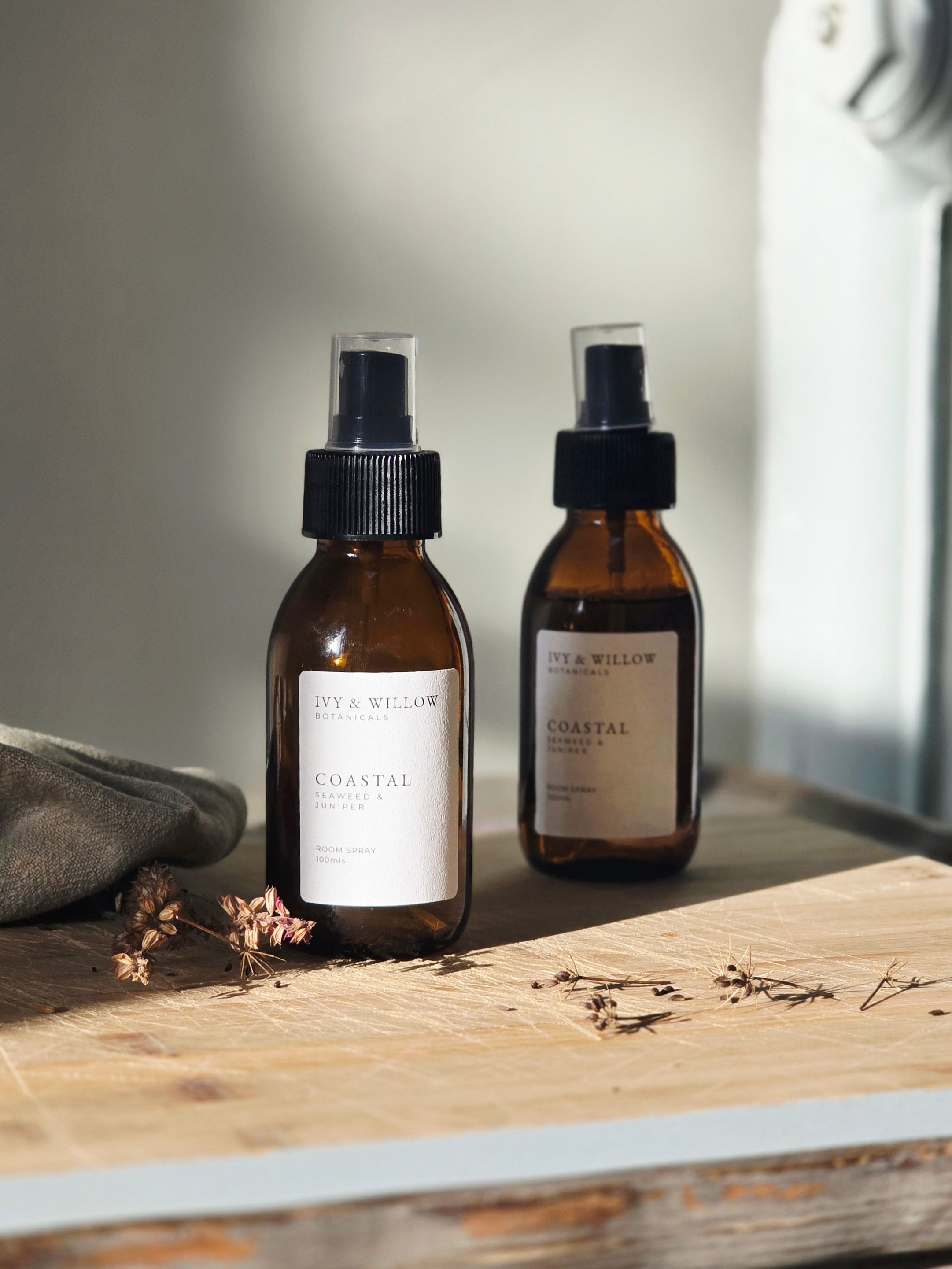 Two brown bottles with black sprayer lids on a wooden surface, labeled 'City & Willow'.