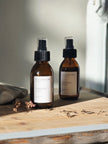 Two brown bottles with black sprayer lids on a wooden surface, labeled 'City & Willow'.