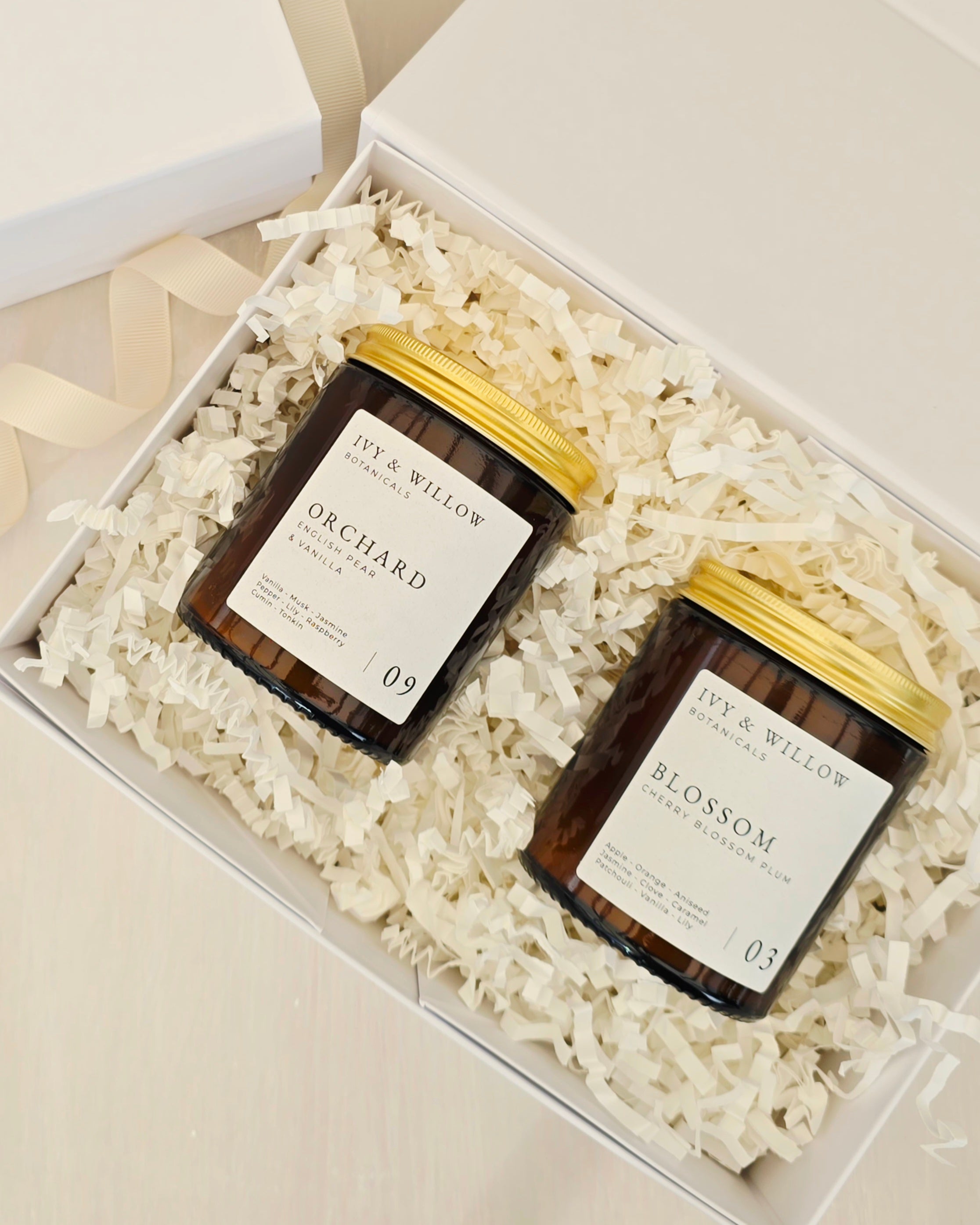 Two candles in a gift box with decorative paper