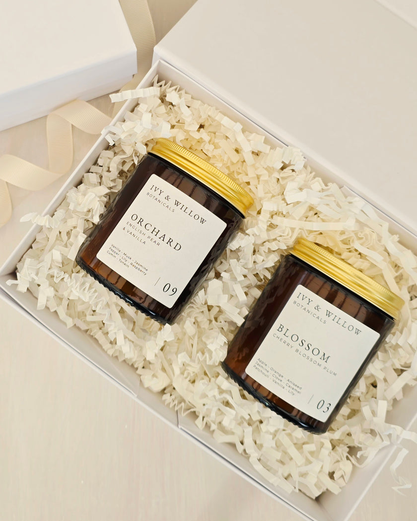 Two candles in a gift box with decorative paper