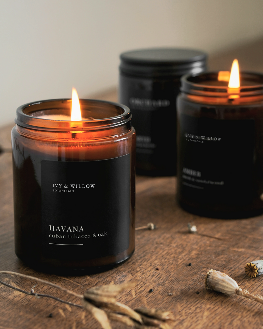 Black candles with 'IVY & WILLOW' branding on a wooden surface.