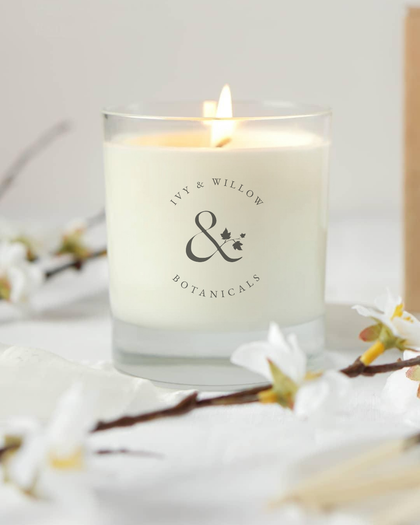 Candle with 'Ivy & Willow Botanicals' logo on a white background with floral elements.
