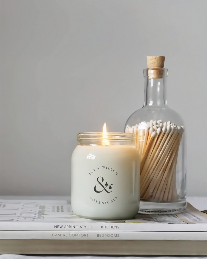 Signature clear Honey Jar 300g candle with gold lid and a bottle of matches on a surface.