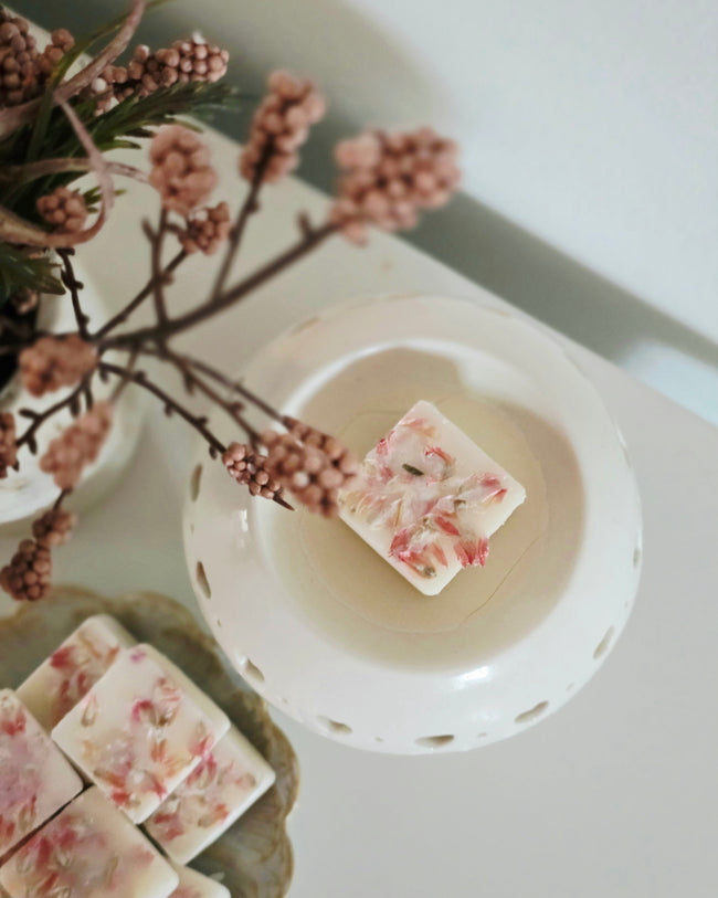 Raspberry & Peppercorn wax melts in a white ceramic wax burner