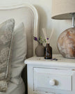 Napkin holder with decorative items on a nightstand next to a bed