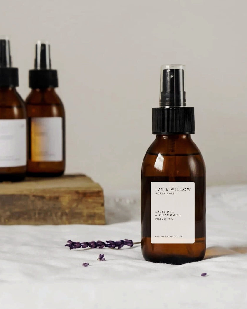 Brown pillow mist spray bottle with a label on a white surface, with additional bottles in the background.