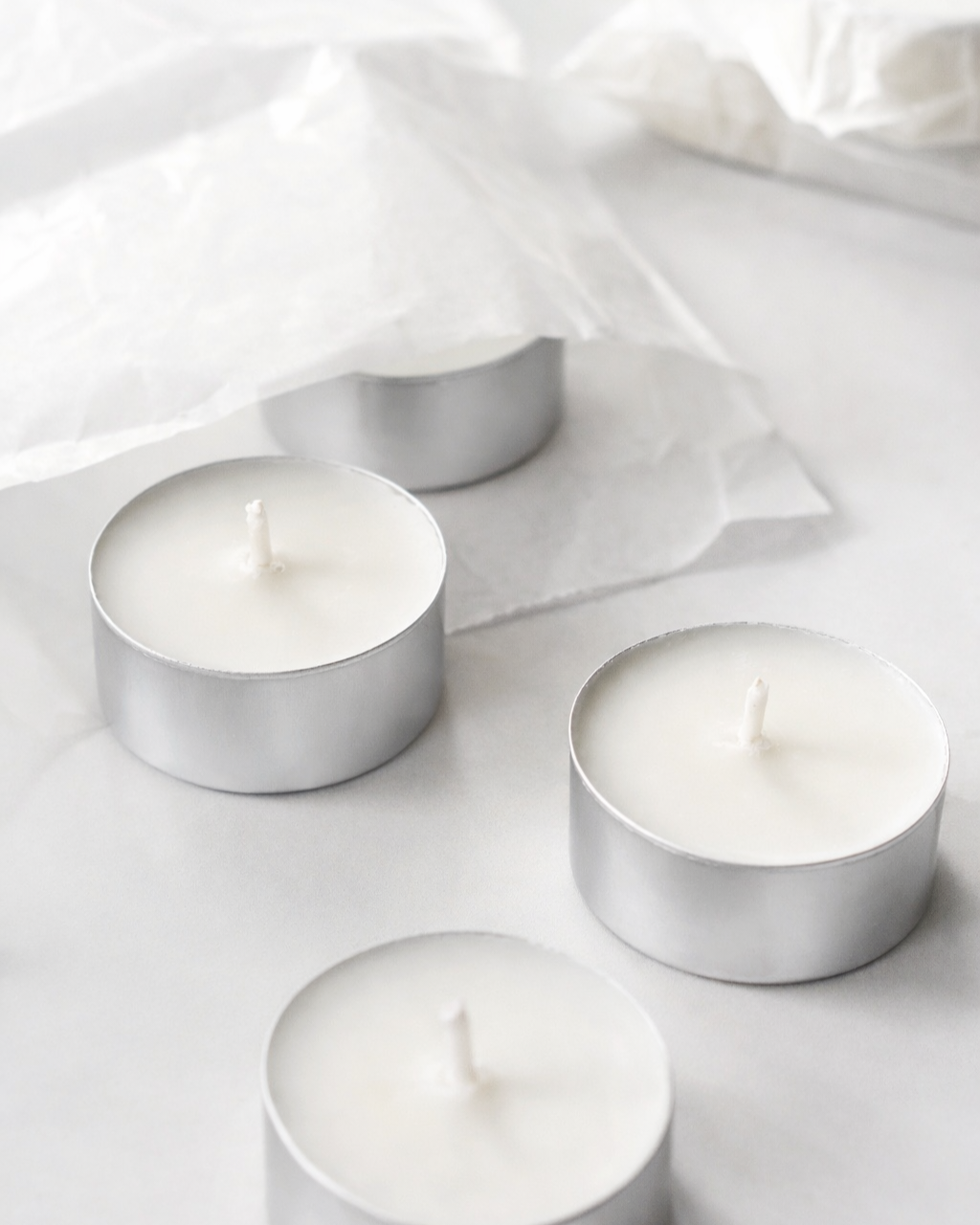 Four Tealights 20mls in silver aluminium holders on a light gray background