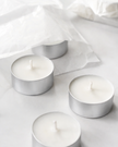Four Tealights 20mls in silver aluminium holders on a light gray background
