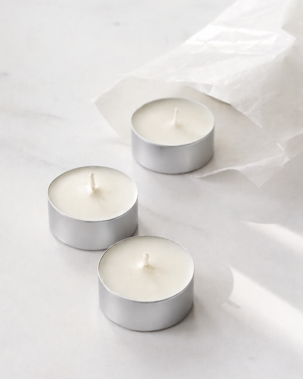 Three Tealights 20mls in silver aluminium holders on a light gray background