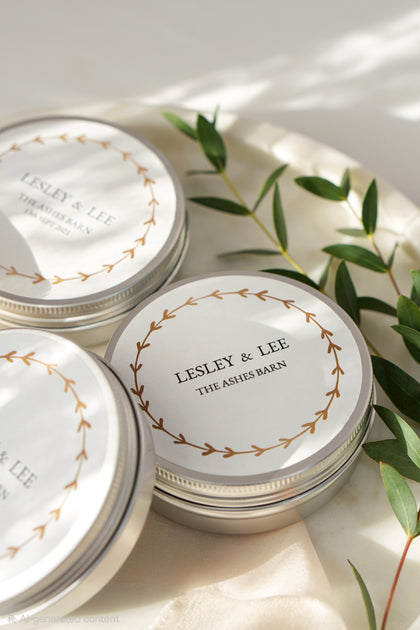 Three 'Lesley & Lee' branded containers on a light surface with green leaves.