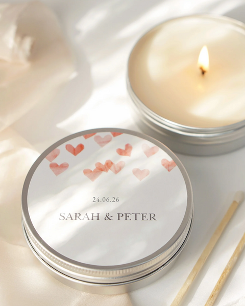 Candle in a tin with 'Sarah & Peter' and heart designs on a marble surface