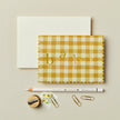 Yellow gingham card with 'baby' text on a beige background
