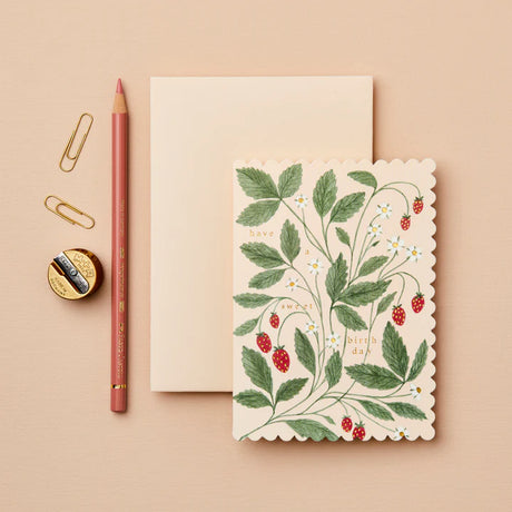 Notebook with floral design, pencil, and paper clips on a beige background