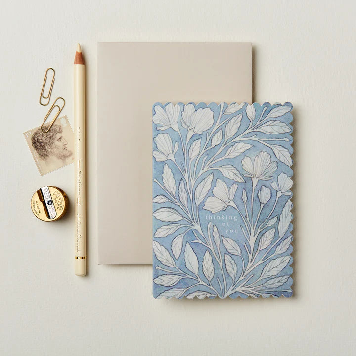 Notebook with floral design, pencil, and paper clips on a light background