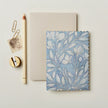 Notebook with floral design, pencil, and paper clips on a light background