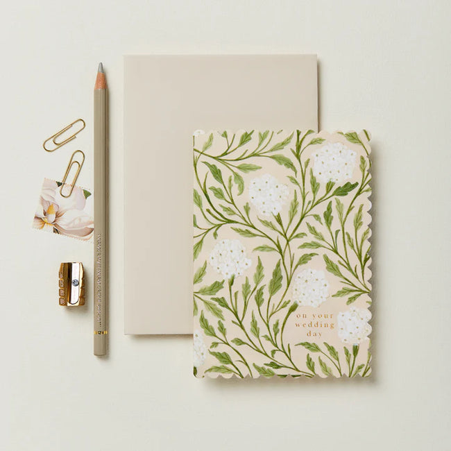 Notebook with floral design and stationery items on a light background