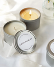 Candle in a tin labeled 'Groomsman' from the 'Wedding Collection' on a white fabric background.