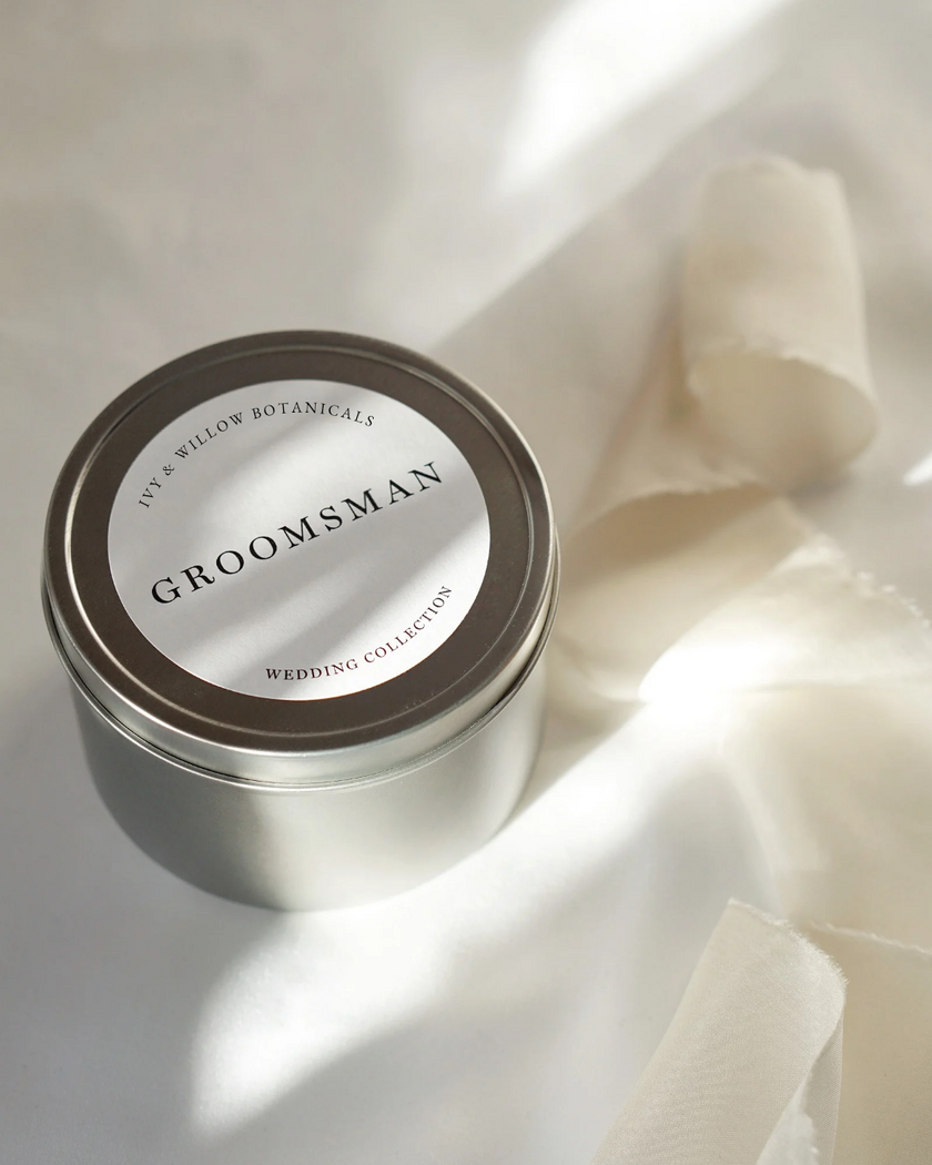 Silver tin labeled 'Groomsman' on a white fabric background